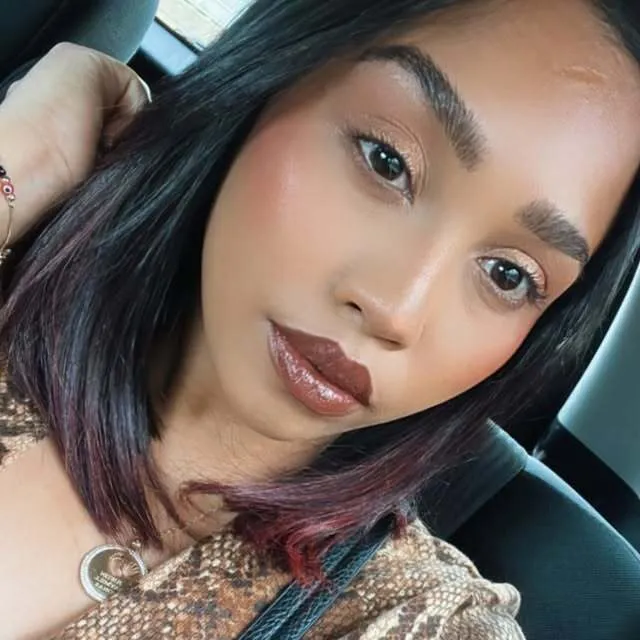 Close portrait with a glossy berry lip, soft blush, and groomed brows.