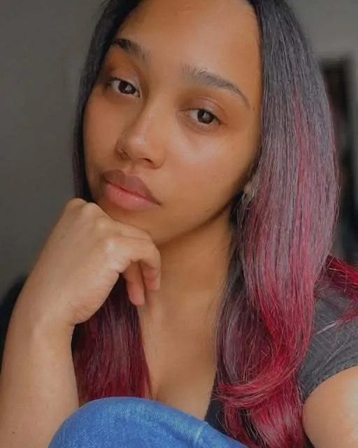 Portrait with long dark hair dyed rose through the lengths.