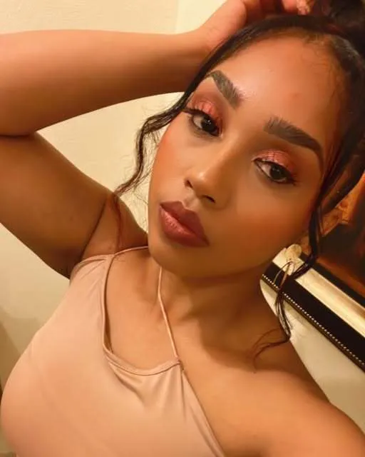 Portrait with warm bronze eye makeup, defined brows, and a nude lip.